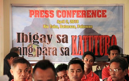 <p><strong>ROYALTY SHARES SOUGHT.</strong> A tarp behind the Pala'wan chieftains of Barangay Rio Tuba, Bataraza, southern Palawan, expresses their appeal to be paid over PHP7-million in royalty shares and penalties by lime milk manufacturer Unichamp.<em> (Photo by Celeste Anna R. Formoso)</em></p>
