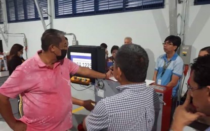 <p>Department of Transportation Secretary Arthur Tugade (left) inspects seven units of manual embossing machines at the Land Transportation Office motor vehicle license plate facility on Friday (April 6, 2018). <em>(Photo courtesy of DOTr)</em></p>