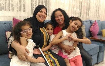 <p><strong>HAPPY TOGETHER.</strong> Rita Versoza enjoys a light moment with her Kuwaiti employer, Roqaya Mohammad Deif and grandchildren. Versoza has been working in Kuwait for 15 years. <em>(Photo by Joyce Rocamora)</em></p>