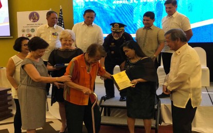 <p>Mrs. Carolina San Juan (holding cane), wife of WW II veteran Cpl. Jose San Juan, receives the posthumous award for her late husband from officials of the Palawan Liberation Task Force. <em>(Photo by Celeste Anna R. Formoso)</em></p>