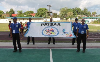 <p>Technical officials from Tagbilaran City carrying the Private Schools Athletic Association Sports Federation, Inc. (PRISAA) flag during the opening ceremony at the Carlos P. Garcia Sports Complex oval on April 22, 2018. <em>(Photo by Rex Lester Binosa/PRISAA)</em></p>