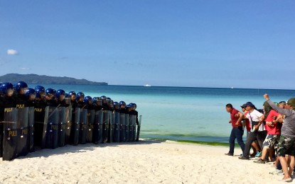 <p><strong>SECURITY SKILLS DEMO</strong>. Some 50 members of the Metro Boracay Task Force demonstrate how to handle 'rallyists' against Boracay closure. The scene is part of the final security capability demonstration held in Boracay on Wednesday (April 25, 2018).  <em>(Photo by Cindy Ferrer/PNA) </em></p>