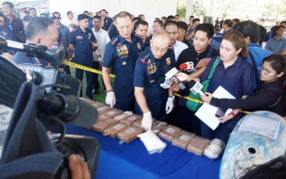 <p><strong>COCAINE</strong>. Newly-installed Chief Philippine National Police Director General Oscar Albayalde inspects the 28 packs of cocaine recovered by Quezon fishermen off the waters of Camarines Nortel last April 15 during a media presentation at Camp Gen. Vicente Lim, Mayapa, Calamba City Tuesday (April 24, 2018). Albayalde was the speaker and guest of honor during the turnover ceremony installing Police Chief Supt. Guillermo Eleazar as new regional director for Police Regional Office (PRO) Calabarzon comprising the provinces of Cavite, Laguna, Batangas, Rizal and Quezon. <em>(Photo by Zen Trinidad)</em></p>