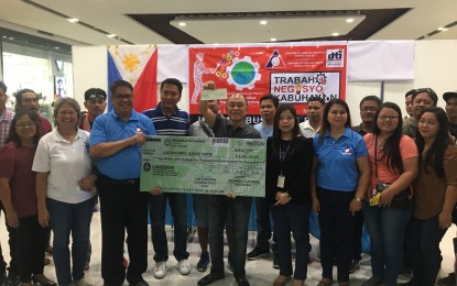 <p><strong>DOLE AIDS</strong>. Department of Labor and Employment Region 1 Director Nathaniel Lacambra (blue shirt) hands over the replica check for PHP2.9 million to the local government unit of Bacarra represented by Mayor Nicomedes dela Cruz <em>(Photo by Leilanie Adriano)</em></p>