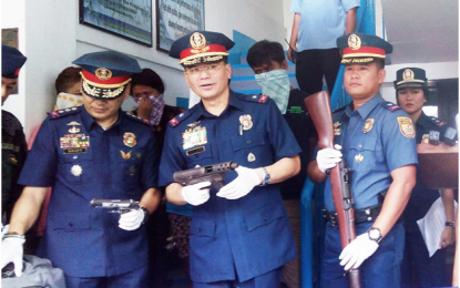 <p><strong>LAGUNA CLASH.</strong> Police Regional Office Calabarzon Director Chief Supt. Guillermo Eleazar (center) and Provincial Director Kirby John Kraft present to media on Thursday (May 3, 2018) the guns seized  from the arrested NPA members at a Comelec checkpoint in Barangay Dambo, Pangil, Laguna on Wednesday (May 2, 2018). The presentation was held at Camp Gen. Paciano Rizal in Sta. Cruz, Laguna. <em><strong>(Photo by Zen Trinidad)</strong></em></p>