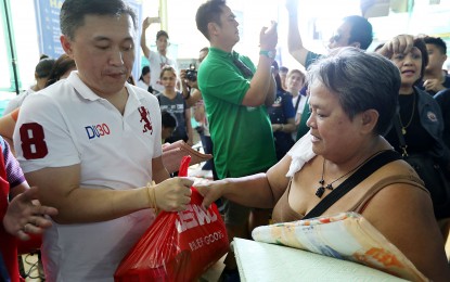 <p><strong>SAP GO DONATES TO FIRE VICTIMS.</strong> Special Assistant to the President Christopher "Bong" Go on Sunday (May 6, 2018) distributes relief to one of the victims of fire that hit Banaag Street, Barangay Pineda, Pasig last Friday. Go said President Rodrigo Duterte sent him to check on the fire victims and distribute some assistance. <em>(PNA photo by Oliver Marquez)</em></p>