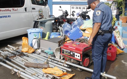 <p><strong>TREASURE HUNTERS</strong>. San Antonio Police chief, Senior Insp. Jonathan Bardaje, inspects the mining equipment and apparatus seized from four Japanese nationals and their Filipino workers who used them for illegal treasure hunting. The Japanese and 13 Filipinos were arrested in Capones Island in Zambales on Thursday (May 31, 2018). <em>(Photo of Ruben Veloria)</em></p>