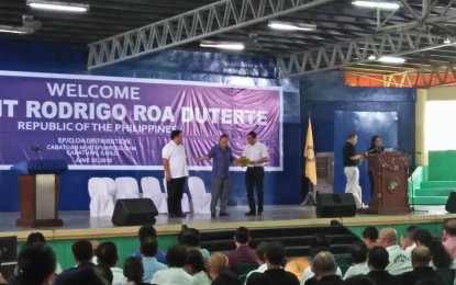 <p><strong>TURNOVER OF ROAD PROJECT.</strong> Lambunao Mayor Jason R. Gonzales receives completed project documents for the PHP57.6 million concreting of junction national road to Agsirab-Bagongbong- Sitio Agdaludan farm-to-market road  on Wednesday (June 20, 2018).<em> (Photo by Perla Lena) </em></p>