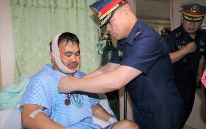 <p><strong>MEDAL FOR BRAVE COP.</strong> Police Regional Office Cordillera director Chief Superintendent Rolando Nana pins on SPO2 Noren Bandao the 'Medalya ng Sugatang Magiting' that was awarded to him for neutralizing a robber, who was facing criminal charges in different provinces in the country. <em>(Photo Courtesy of Procor)</em></p>