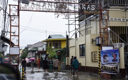 <p><strong>WATER WORLD. </strong>Residents wade through gutter-deep floods in Barangay Wakas in Imus, Cavite which has been battered by occasional heavy rains for the past eight days. <strong><em>(</em></strong><strong><em>Photo by </em></strong><strong><em>Dennis Abrina)</em></strong></p>