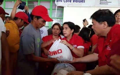 <p>RELIEF OPERATION. DSWD Secretary Virginia Orogo (center) leads the distribution of family food packs to disaster-affected fishermen and farmers in Narvacan, Ilocos Sur. <em><strong>(Photo courtesy of DSWD Regional Office 1) </strong></em></p>