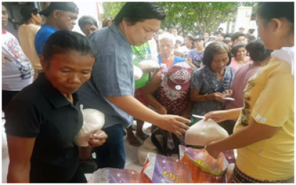 <p><strong>RELIEF GOODS.</strong> Noveleta, Cavite Mayor Dino Reyes Chua distributes rice packs to the flood-affected families in the town’s submerged villages on Tuesday (July 24).<em> (Photo by Dennis Abrina)</em></p>
