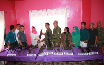 <p><strong>MORE YIELDED FIREARMS</strong>. Mayor Anida Abas-Dimaukom of Datu Saudi Ampatuan, Maguindanao, hands over a firearm to Brigadier General Diosdado Carreon, commander of the Army’s 601st Brigade, during the ceremonial turnover of ten high-powered loose firearms at the town hall on Friday (July 27, 2018). On April this year, the town also yielded 17 loose firearms to military authorities <em><strong>(Photo by 6ID)</strong></em></p>