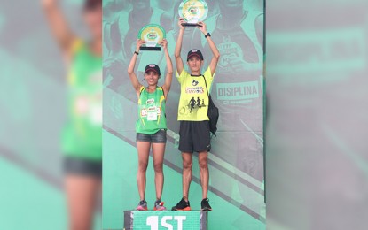 <p><strong>MILO CHAMPS.</strong> Christine Hallasgo (left) and Jeson Agravante (right) pose with their trophies after topping their respective divisions in the Manila leg of the 42nd National MILO Marathon at the Mall of Asia in Pasay City on Sunday (July 29, 2018). <em>(PNA photo by Jess M. Escaros Jr.)</em></p>