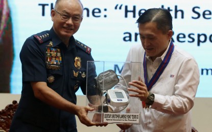 <p><strong>TOKEN OF APPRECIATION.</strong> Special Assistant to the President Christopher Lawrence Go receives a token of appreciation from Philippine National Police (PNP) chief Director General Oscar Albayalde as the former served as guest of honor and speaker during the PNP Health Service's 25th anniversary held at the PNP Multi-Purpose Hall in Camp Crame, Quezon City on Wednesday (Aug. 1, 2018). Go said PNP health service is a "fine way" to give lawmen and their families medical treatment without having to shell out money from their pocket. <em>(PNA photo by Joey Razon)</em></p>