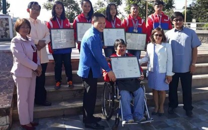 <p><strong>PARA-GAMES WINNERS.</strong> Baguio City Vice Mayor Edison Bilog hands over to Agustina Bantiloc (in wheelchair) the framed copy of the city council resolution commending her and 14 other para- athletes from the city for their contribution to sports promotion and bringing home 32 medals from the 2018 PHILSPADA National Para Games held at the Marikina Sports Center in May this year. <em>(Photo by Pamela Mariz Geminiano)</em></p>