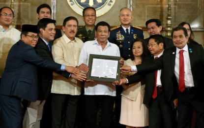 <p><strong>PEACEFUL MINDANAO.</strong> President Rodrigo Roa Duterte poses for a photo with the legislators and negotiators in the peace process with the Moro Islamic Liberation Front (MILF), as well as top military and police officials during the presentation of the Bangsamoro Organic Law (BOL) to the MILF at Malacañan Palace on Aug. 6, 2018. Duterte on Saturday (March 12, 2022) said that he has been able to deliver his promise to bring peace to Mindanao. <em>(Presidential file photo)</em></p>