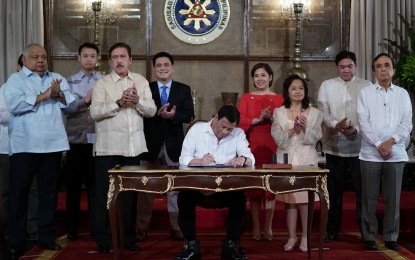 <p><strong>PHILSYS ACT.</strong> President Rodrigo R. Duterte enacts the signing of the Philippine Identification System (PhilSys) Act during a ceremony at Malacañan Palace on August 6, 2018.<em> (King Rodriguez/Presidential Photo) </em></p>