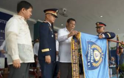 <p><strong>BEST POLICE STATION.</strong> President Rodrigo Duterte graces the awarding ceremonies that recognized the the La Trinidad Municipal Police Station as the Philippines' top police station. La Trinidad chief of police Benson Macliing (rightmost) receives the award on the town cops' behalf. Also in photo are Department of the Interior and Local Government Secretary Eduardo Año (leftmost) and Philippine National Police Chief Director General Oscar Albayalde (2nd from left) to celebrate the 117th Police Service Anniversary at Camp Crame in Quezon City on Wednesday (Aug. 8, 2018). <em>(Photo courtesy of La Trinidad Municipal Police Community Relations Office - Photo Grab from RTVM)</em></p>