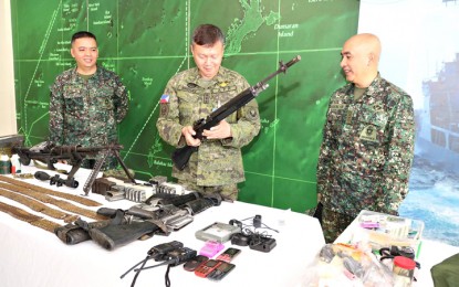 <p><strong>RECOVERED NPA FIREARMS.</strong> (From left) Lt. Col. Darwin de Luna, commander of the 4th Marine Battalion Landing Team and Joint Task Group South (JTGS); Western Command commander, Lt. General Rozzano Briguez (middle, holding a recovered firearm), and Col. Charlton Sean Gaerlan, commander of the 3rd Marine Brigade (MBde) and the Joint Task Force Peacock (JTFP), during the presentation on Sunday of the recovered firearms following a clash with the NPA by government troops in Barangay Quinlogan, Quezon, southern Palawan. <em>(Photo courtesy of Wescom Public Affairs Office) </em></p>