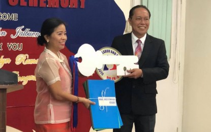 <p><strong>TURNOVER RITES</strong>. Former Department of Labor and Employment (DOLE) National Capital Region (NCR) Director Henry John S. Jalbuena (right) receives the symbolic key and documents from his predecessor, DOLE Calabarzon director officer-in-charge Atty. Evelyn R. Ramos (left), during a turnover ceremony on Aug. 6, 2018. <em>(Photo courtesy of DOLE IV-A)</em></p>