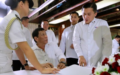 <p><strong>DISMISSAL ORDER.</strong> President Rodrigo R. Duterte signs the dismissal order of Philippine Military Academy comptroller Hector Maraña at the Malacañan Palace on August 14, 2018, for his alleged misuse of the PHP15-million worth of allowance for the cadets. <em>(Presidential Photo)</em></p>