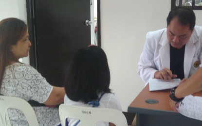 <p><strong>DENGVAXIA PROFILING</strong>. Sta Rosa Community Hospital Medical Director Dr. Parnell Patacsil (rightmost) checks on the Dengvaxia vaccinee's provided data at the start of the Department of Health physical examination activities held at the Sta Rosa Community Hospital on Friday. <em>(Photo courtesy of Gladys S. Pino/PNA)</em></p>