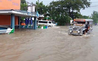 <p><strong>FLOODWATER.</strong> A public utility jeepney manages to make way through floodwaters along a national highway in Baay, Batac, Ilocos Norte.<em> (Photo by Leilanie Adriano/PNA)</em></p>