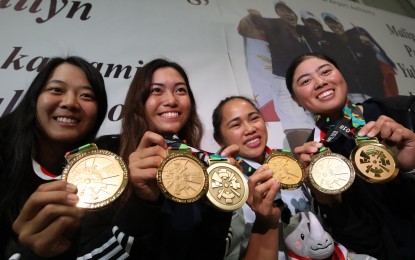 <p><strong>GOLDEN GIRLS.</strong> Weightlifter Hidilyn Diaz, golfers Yuka Saso, Loisa Kaye Go, and Bianca Pagdanganan proudly show the gold medals they won at the 2018 Asian Games in Jakarta-Palembang upon arrival at the Ninoy Aquino Internationa Airport in Pasay City on Tuesday evening (August 28, 2018). <em>(PNA photo by Avito C. Dalan)</em></p>