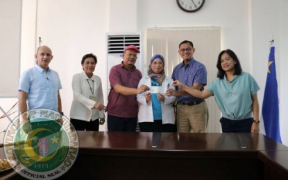 <p><strong>PCSO ASSISTANCE.</strong> Philippine Charity Sweepstakes Office General Manager Alexander Balutan (2nd from right) turns over a PHP1-M assistance fund to officials of the Buluan District Hospital in Maguindanao. The PCSO also opened an office in Buluan town on Tuesday (Sept. 11, 2018). <em>(Photo courtesy of Sau Sing/Maguindanao provincial government)</em></p>