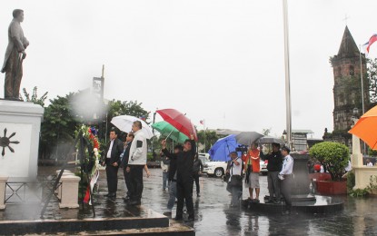 <p><strong>UNMINDFUL OF RAINS, WINDS.</strong> National Historical Commission of the Philippines Executive Director Ludivico Badoy, together with Governor Wilhelmino Sy-Alvarado, and City of Malolos Mayor Christian D. Natividad, leads the wreath laying ceremony at  the monument of President Emilio Aguinaldo in front  of Barasoain Church despite heavy winds and rains brought by typhoon Ompong on Saturday (September 15, 2018). <em>(Photo courtesy of the Malolos City Information Office)</em></p>