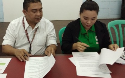 <p>Eric Malo-oy, officer-in-charge campus director of TUP-Visayas, and Bacolod City National High School OIC-principal Laila Arro in a recent signing of a memorandum of agreement on educational and institutional partnerships for basic education. <em>(Contributed photo)</em></p>