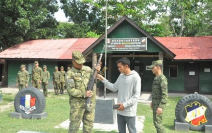 <p><strong>SURRENDER.</strong> New People’s Army member Danny Boy Makatin (right) hands over his M16 rifle to Lt. Col. Harold Cabunoc, Army’s 33rd Infantry Battalion commander (left), during his surrender Monday (Sept. 17, 2018) at the 33rd IB headquarters in President Quirino, Sultan Kudarat province. <em>(Photo by Philippine Army's 6ID)</em></p>