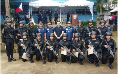 <p><strong>GENTRI  SWAT – </strong>Police Regional Office (PRO4A) Calabarzon Regional Director Chief Supt. Edward Carranza (4th from right), Cavite Police Provincial Director Senior Supt. William Segun (5th from left), Supt. Paul Bometivo, chief of police of General Trias City (4th from left) and General Trias City Mayor Antonio 'Ony' Ferrer (center, standing) grace the graduation rites of the 13 newly-trained Special Weapons and Tactics (SWAT) Team in Camp Francisco Ferma in Tagaytay City on Sept. 13, 2018. <strong><em>(Photo courtesy of GenTri PNP) </em></strong></p>