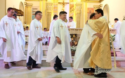<p><strong>NEW PRIEST.</strong> Brother-priests of the Dumaguete clergy line up for a hug to welcome newly-ordained Fr. Alvin Villaflores. <em>(Photo by Judaline F. Partlow)</em></p>