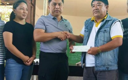 <p><strong>FINANCIAL AID</strong>. National Housing Authority (NHA) general manager Jun Escalante (2nd from left) turns over a PHP10-million cheque to Itogon Mayor Victorio Palangdan (3rd from left) on Saturday (September 29), representing the agency’s immediate assistance to the victims of typhoon ‘Ompong’ in Itogon. Also in photo is Presidential Communications Operations Office (PCOO) Assistant Secretary for Operation and Legislative Affairs Marie Rafael Banaag (leftmost), who helped facilitate the donation.<em> (Photo by Liza T. Agoot</em>)</p>