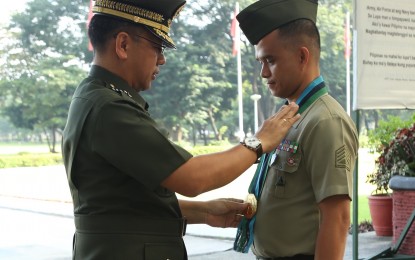 <p>Armed Foces of the Philippines (AFP) Chief of Staff General Carlito Galvez Jr. pins the Gold Cross Medal to one<br />of the 18 awardees during the flag-raising ceremony at the AFP General Headquarters Canopy Area in Camp<br />Aguinaldo, Quezon City on Monday (Oct. 1, 2018). <em>(Photo courtesy: AFP Public Affairs Office)</em></p>
