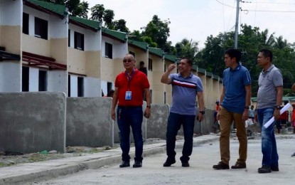 <p>National Housing Authority (NHA) General Manager Marcelino Escalada (blue shirt) together with officials of the NHA in Davao region inspect the frist completed housing units for the former New People's Army (NPA) rebels in Tagum City on Friday. <em><strong>Photo by Lilian C Mellejor/PNA</strong></em></p>