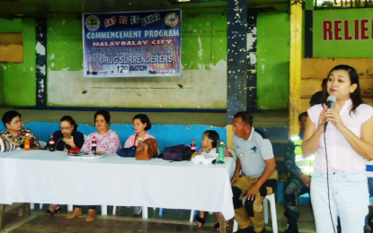 <p>File photo of Maria Maida Daniot (standing, right), city local government operations officer, during the commencement program of the 12th batch of Malaybalay City Community-Based Rehabilitation Program (CBRP) on August 25 held at Brgy. 9 covered court in Malaybalay. <em>(Photo by Mel B. Madera)</em></p>