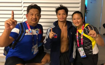 <p><strong>GOLD WINNER.</strong> Paralympian Ernie Gawilan (center) poses with coaches Tony Ong and Majonie Palumbarit after winning his second gold medal in swimming at the 2018 Asian Para Games in Jakarta, Indonesia on Wednesday (Oct. 10, 2018) <em>(Contributed photo)</em></p>