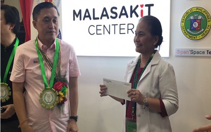 <p><strong>SEED FUNDING.</strong> Governor Celestino Gallares Memorial Hospital deputy chief Dr. Nonaluz Pizzaras proudly shows the envelop containing the P5-million check as seed funding for the Malasakit Center in Bohol, which was inaugurated by Special Assistant to the President Christopher Lawrence 'Bong' Go on Friday (October 12, 2018).<em> (Photo by Dave Albarado)</em></p>