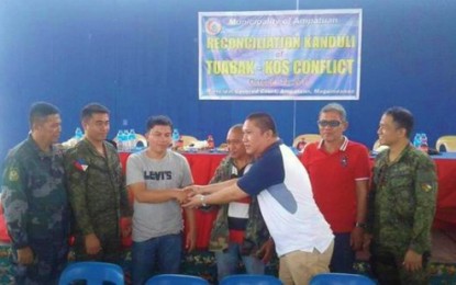 <p><strong>FEUD SETTLEMENT. </strong>Representatives of the Tuabak Sangki and Esmail Kos Klah families shake hands marking the end of their 30-year dispute on Saturday (Oct. 13) in Ampatuan, Maguindanao. <em><strong>(Photo courtesy of Jom K. Dimapalao - Brigada Cotabato)</strong></em></p>