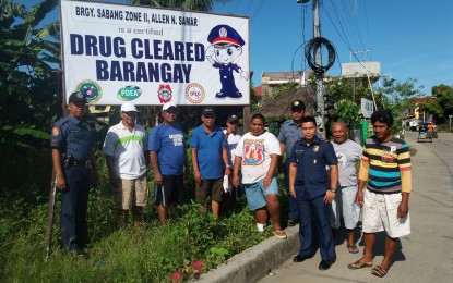 <p><strong>DRUG-CLEARED.</strong> Policemen and village officials post a drug-cleared signage in one of the communities in Allen, Northern Samar. <em>(Photo by Allen Philippine National Police) </em></p>
