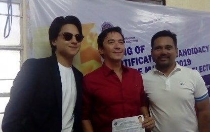 <p>Actor and incumbent Nueva Ecija first district board member Rommel Padilla (center) files his certificate of candidacy for a congressional post at the Commission on Elections office in Cabanatuan City on Tuesday, Oct. 16, 2018.<em><strong> </strong></em>Beside him is his son, matinee idol Daniel Padilla (left). <em>(Photo by Marilyn Galang)</em></p>