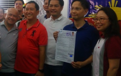 <p>Jose Francisco Benitez (2<sup>nd </sup>from right), president of Philippine Women’s University, holds his certificate of candidacy on Tuesday (October 16, 2018) to succeed his brother Alfredo Benitez (3<sup>rd</sup> from right) as representative of Negros Occidental’s third district, in the presence of his wife Charlotte (right) and allies of Love Negros. <em>(Photo by Nanette L. Guadalquiver)</em></p>