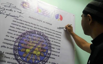<p><strong>INTEGRITY PLEDGE.</strong> Benguet Provincial Board Member Johnny Waguis, who is running for vice governor in next year's midterm elections, signs the integrity pledge during Comelec-Benguet's voters' education cum Gender and Development event and signing of integrity pledge among candidates for various electoral posts in the province on Tuesday (Oct. 23, 2018). <em>(Photo by Liza T. Agoot)</em></p>