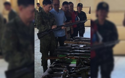 <p><strong>SURRENDERED GUNS.</strong> Colonel Benedict Arevalo, Commander of the 301st Infantry Brigade, inspects the assorted firearms given up by NPA surrenderers during the mass surrender ceremony in Capiz on Monday (October 22, 2018). <em>(Photo by 301st Infantry Brigade)</em></p>