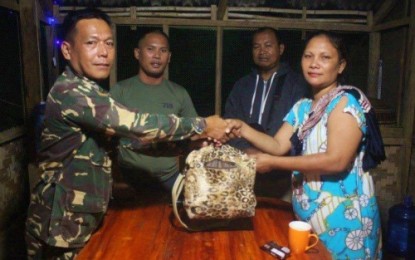 <p><strong>HONEST SOLDIER.</strong> Staff Sergeant Algem Obelidon (left) of the Army’s 7th Infantry Battalion (IB) hands over the bag they found along the roadside on Tuesday (Oct. 23, 2018) in Pagalungan, Maguindanao, to its rightful owners. The bag contained cash of various denominations and PHP100,000 worth of jewelry items <em><strong>(Photo courtesy of 7th IB)</strong></em></p>