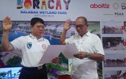 <p><strong>OATH-TAKING.</strong> Acting Malay Mayor Abram Sualog (left) takes his oath of office before Interior officer-in-charge Eduardo Año on the sidelines of the Boracay reopening ceremony on Friday,(October 26, 2017). <em>(Photo by Karen Bermejo) </em></p>