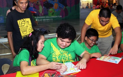 <p><strong>ART FRIDAY</strong>. A member of the 1 San Mateo Artists Guild assists a child with autistic spectrum disorder as he crafts his own artwork at SM City San Mateo, Rizal on Friday (Oct. 26, 2018). The group is composed of visual artists who are from San Mateo, Rizal. <em>(PNA photo by Gil Calinga)</em></p>